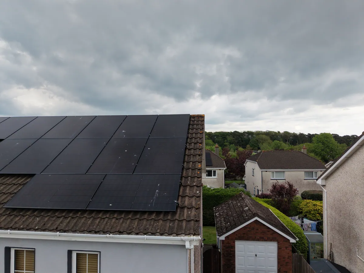 A home rooftop solar array photographed under an overcast sky.