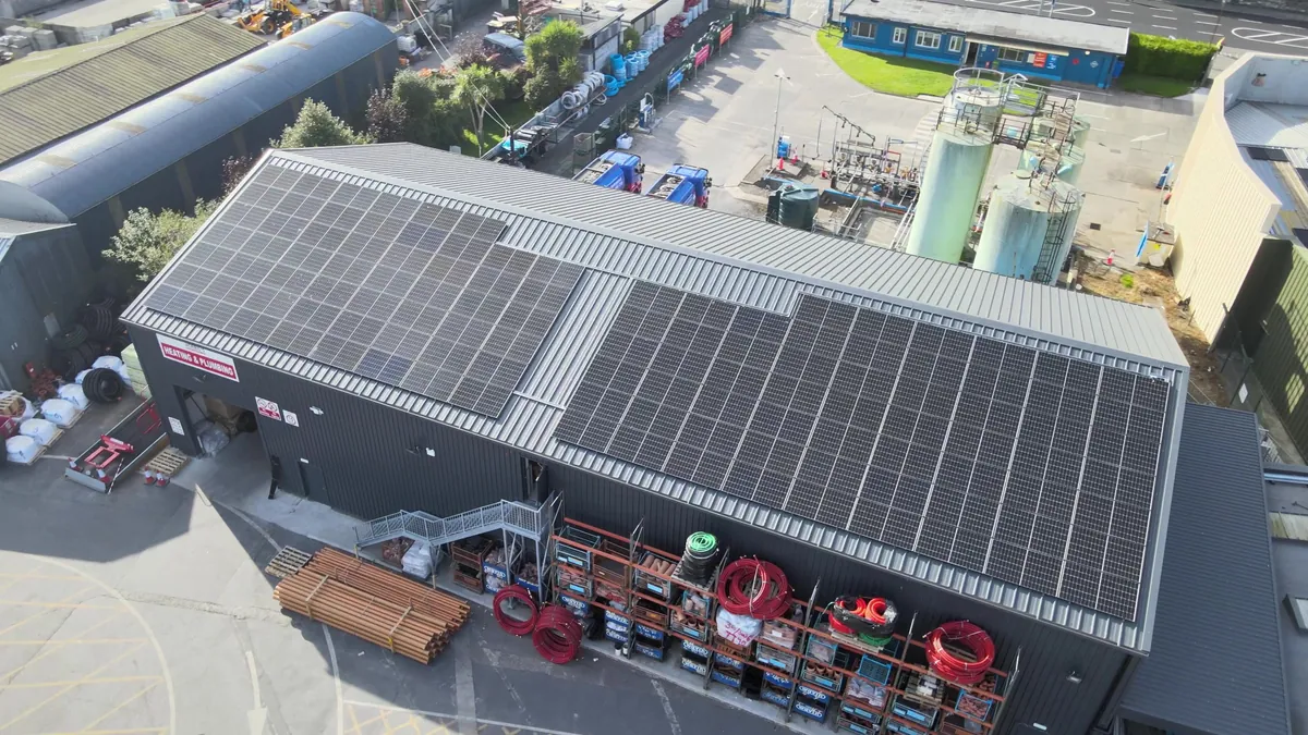 Aerial view of solar panels installed across the roof of a commercial building